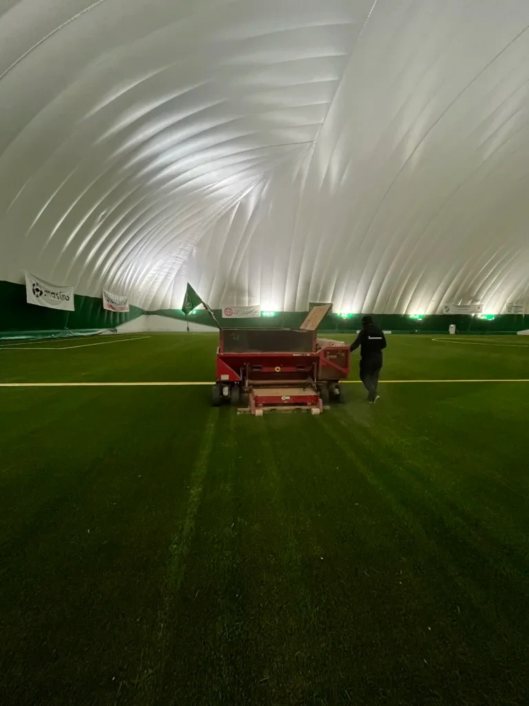 Tekonurmikentän harjaus ja huolto käynnissä